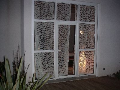 Filet snow install&eacute; en tant que rideau, vu de l'ext&eacute;rieur en soir&eacute;e.